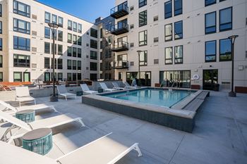 a pool with lounge chairs in front of an apartment building at Marquee, Minnesota, 55403